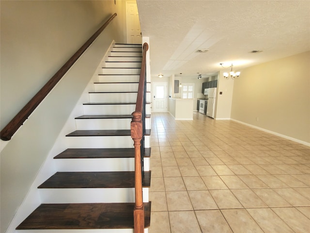 2030 Plantation Dr Unit B-2, Conroe, TX 77301 - staircase with a chandelier, tile patterned floors, a textured ceiling, and baseboards