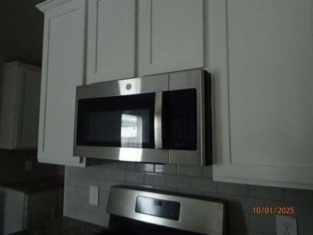 kitchen with backsplash and white cabinetry