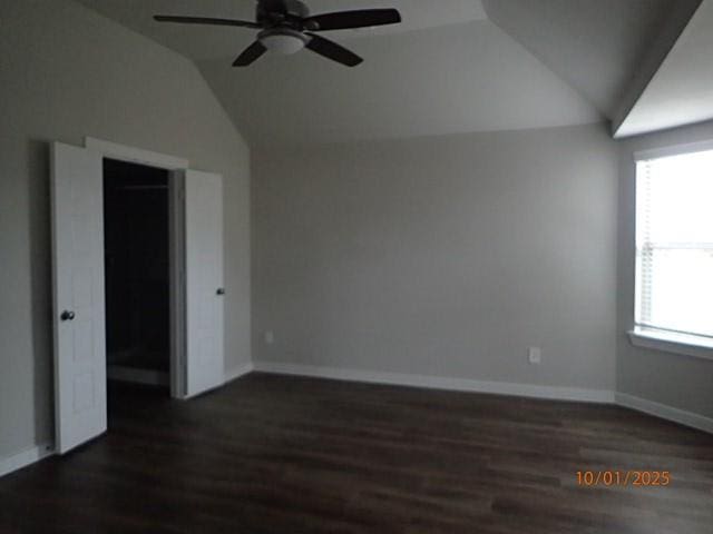 empty room featuring ceiling fan, plenty of natural light, and lofted ceiling