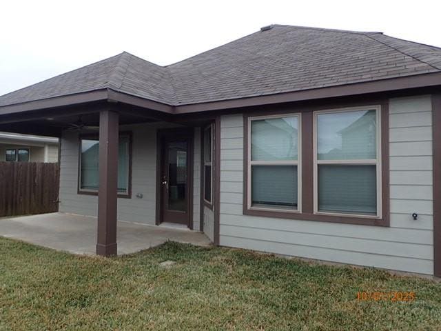 back of property with a lawn and a patio