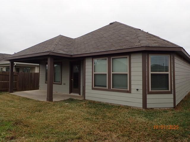 back of house with a lawn and a patio