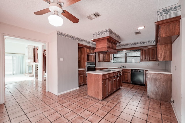 kitchen featuring a textured ceiling, a center island, ceiling fan, light tile patterned floors, and black appliances