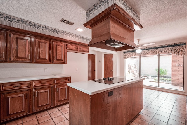 kitchen with a textured ceiling, ceiling fan, black electric stovetop, and a center island