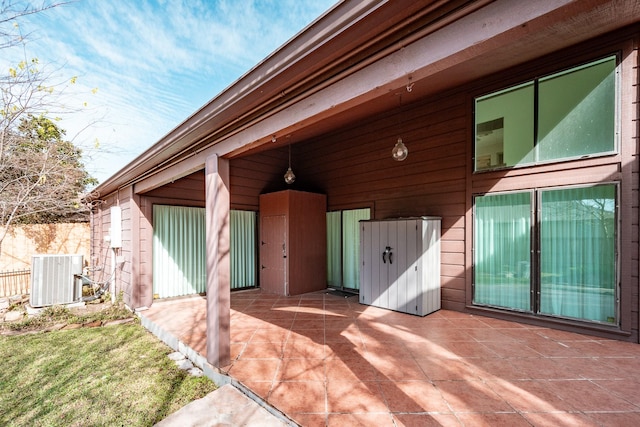 view of exterior entry featuring a patio area and cooling unit