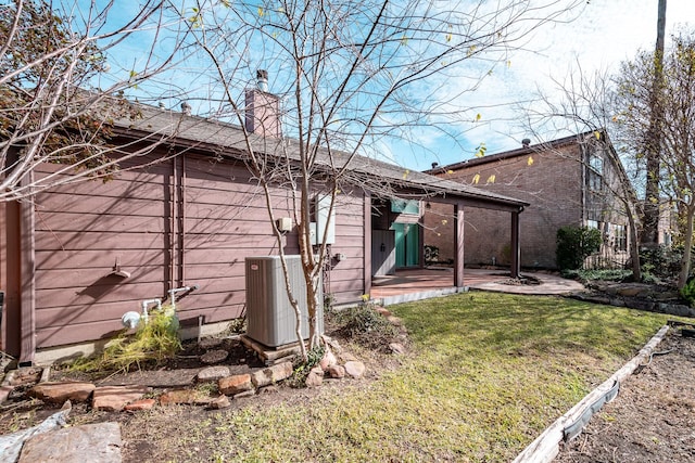 back of property with a lawn and central air condition unit