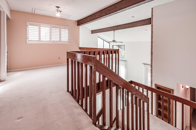 corridor featuring carpet flooring, a textured ceiling, and lofted ceiling with beams