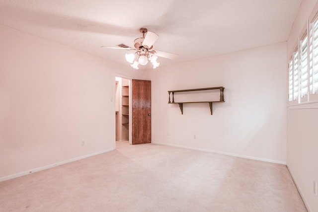 carpeted spare room featuring ceiling fan