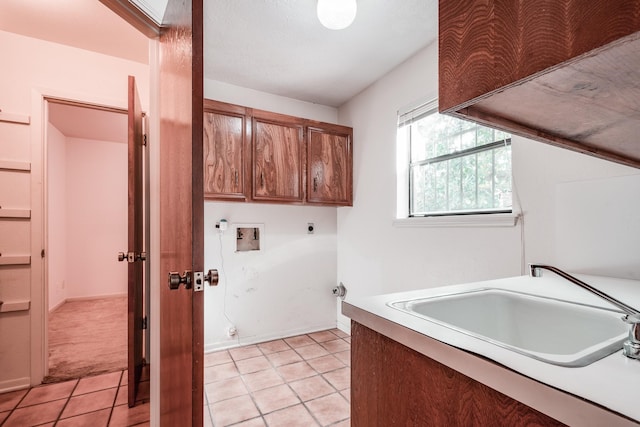 clothes washing area featuring cabinets, hookup for an electric dryer, light tile patterned floors, and washer hookup