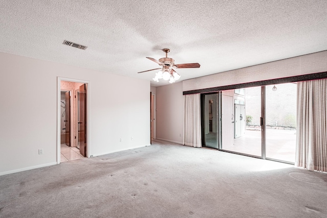 unfurnished room with ceiling fan, light carpet, and a textured ceiling