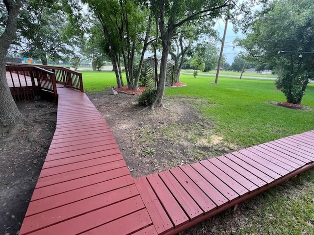 wooden terrace featuring a lawn