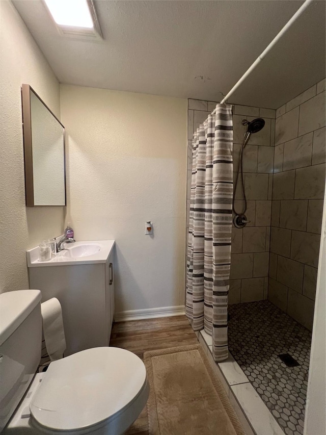 bathroom featuring a shower with shower curtain, vanity, hardwood / wood-style flooring, and toilet