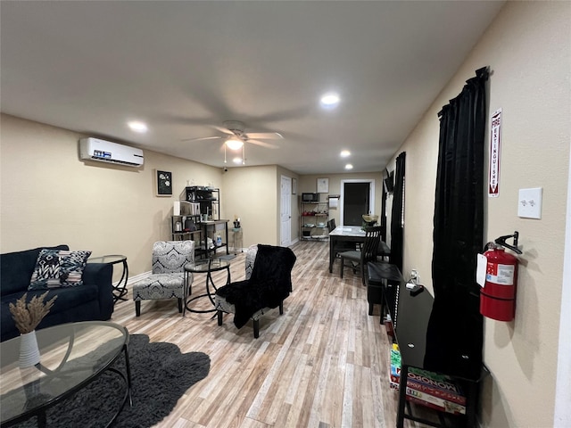 living room with an AC wall unit, ceiling fan, and light wood-type flooring