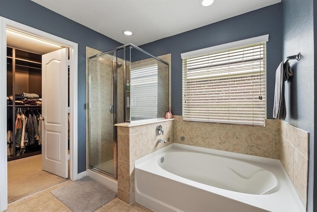 bathroom with tile patterned flooring and shower with separate bathtub