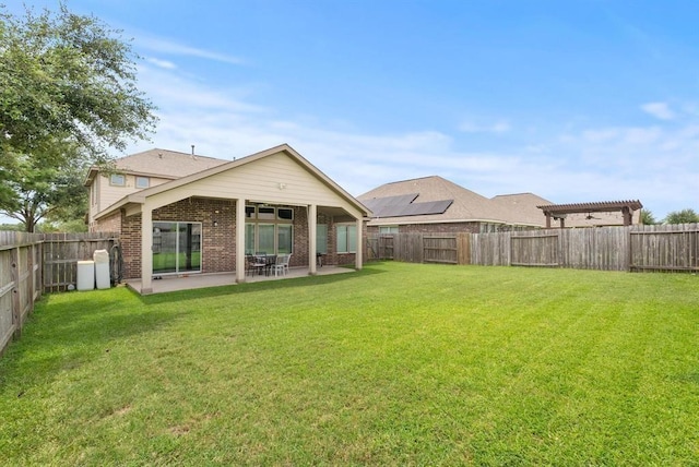 rear view of house featuring a patio, a pergola, and a lawn