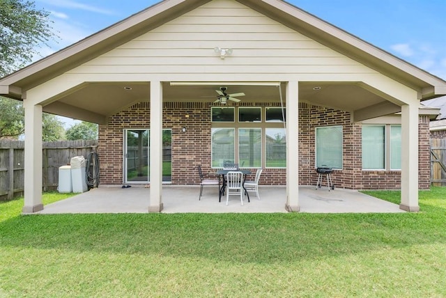 back of property with a lawn, ceiling fan, and a patio area