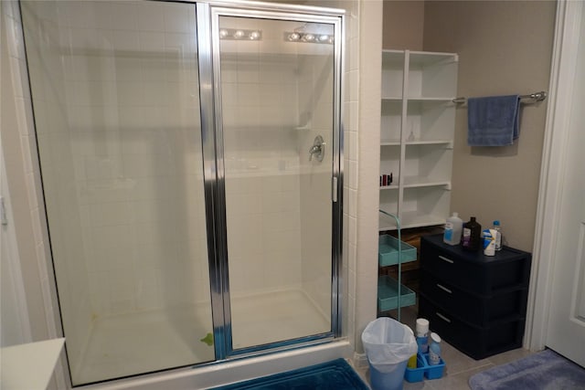 bathroom with an enclosed shower and tile patterned floors