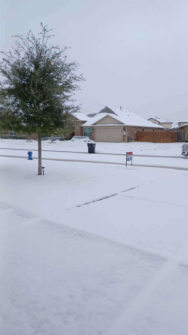 snowy yard featuring fence