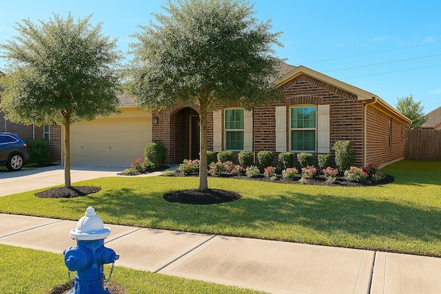 view of front of property featuring brick siding, an attached garage, driveway, and a front yard