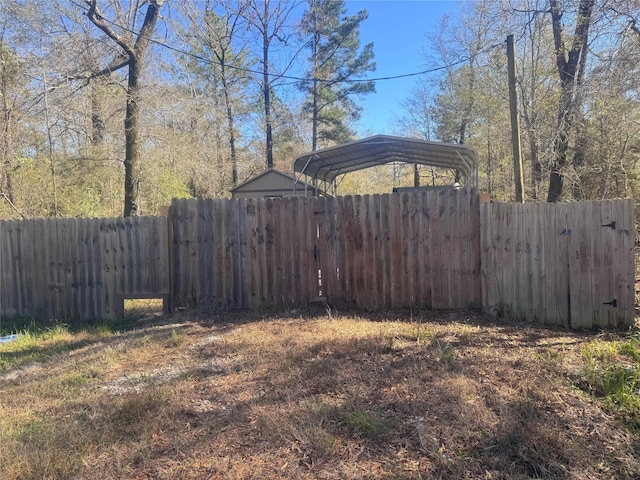 view of yard with a detached carport and fence