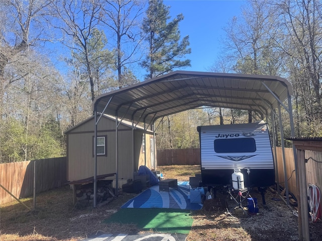 view of vehicle parking with a fenced backyard and a detached carport