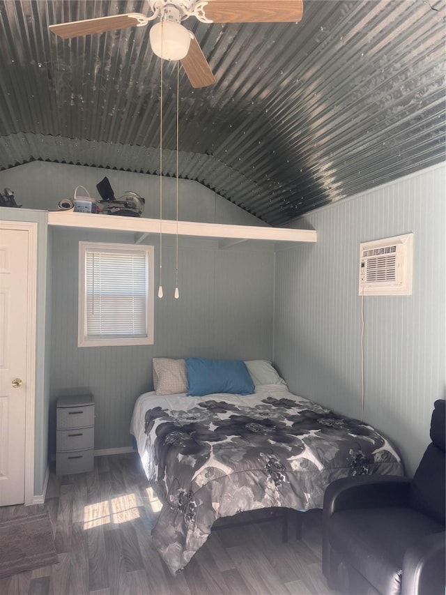 bedroom featuring a wall mounted air conditioner, wood-type flooring, vaulted ceiling, and ceiling fan