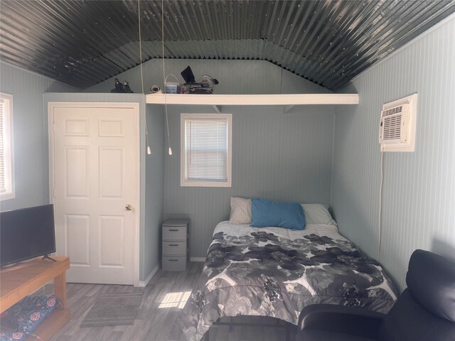 bedroom featuring hardwood / wood-style flooring and a wall mounted AC