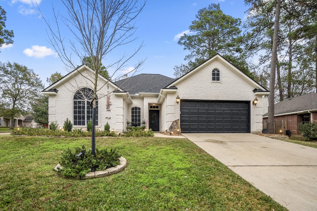 view of front of home with a garage and a front lawn