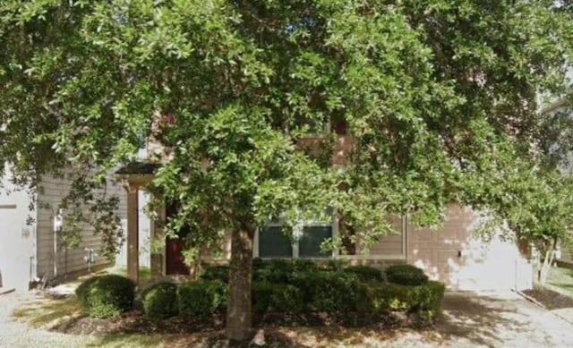 obstructed view of property with a garage