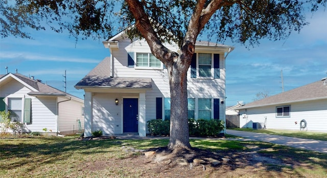 view of front of home with central air condition unit and a front yard