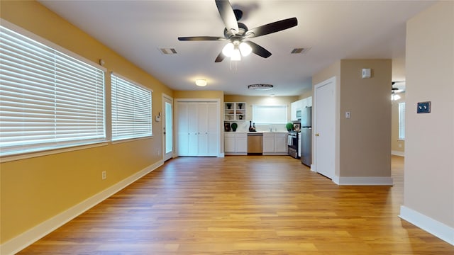 unfurnished living room with ceiling fan and light wood-type flooring