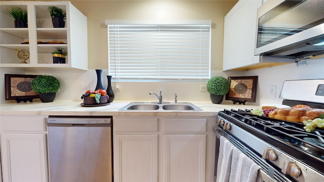 kitchen with light stone counters, white cabinetry, sink, and appliances with stainless steel finishes