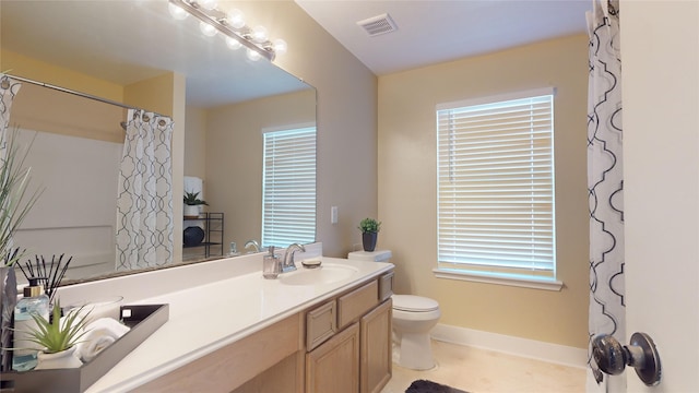 bathroom with tile patterned floors, vanity, toilet, and walk in shower