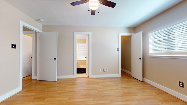 unfurnished bedroom featuring ensuite bath, ceiling fan, and light wood-type flooring