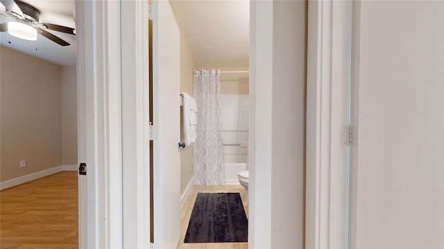 bathroom with shower / bath combo, ceiling fan, toilet, and wood-type flooring