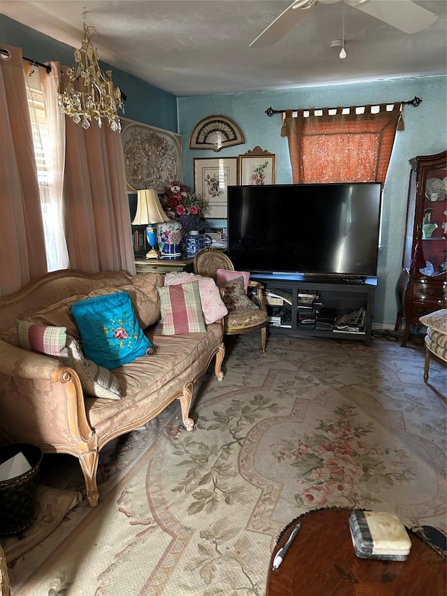 sitting room featuring ceiling fan with notable chandelier