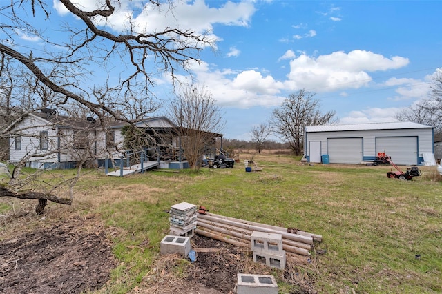 view of yard featuring a garage and an outbuilding