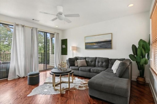 living room featuring ceiling fan and dark hardwood / wood-style floors