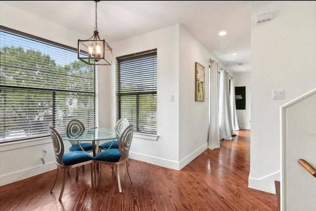 dining room with a healthy amount of sunlight, hardwood / wood-style flooring, and a notable chandelier