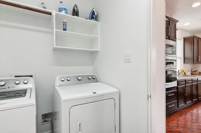 clothes washing area featuring washer and dryer, dark hardwood / wood-style flooring, and sink