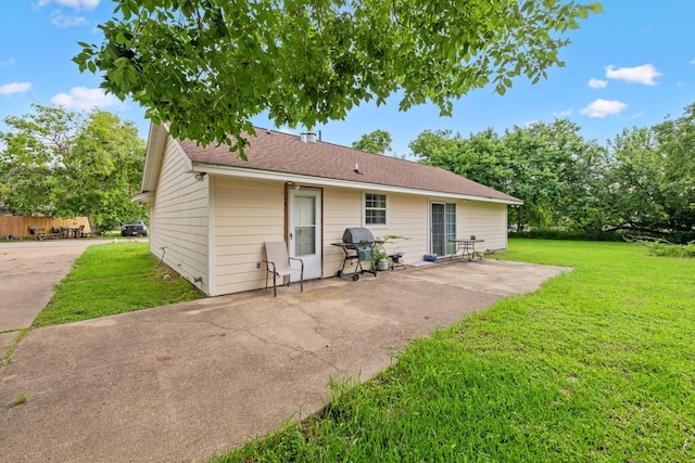 back of house with a patio area and a yard