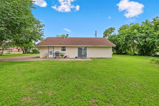 rear view of property with a yard and a patio