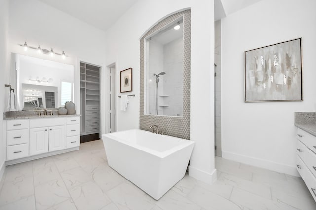 bathroom featuring tasteful backsplash, vanity, and shower with separate bathtub