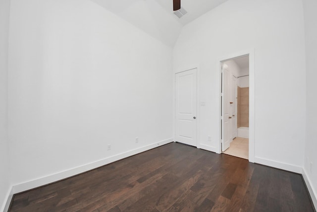 empty room featuring high vaulted ceiling and dark wood-type flooring