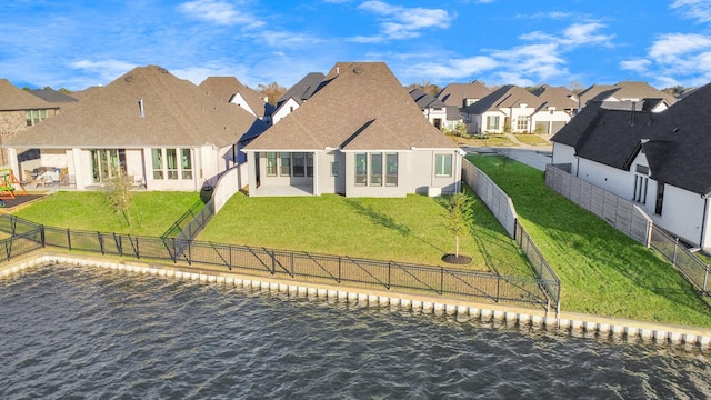 rear view of property with a lawn and a water view