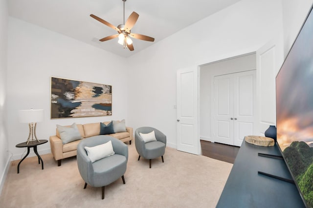 sitting room with ceiling fan and carpet