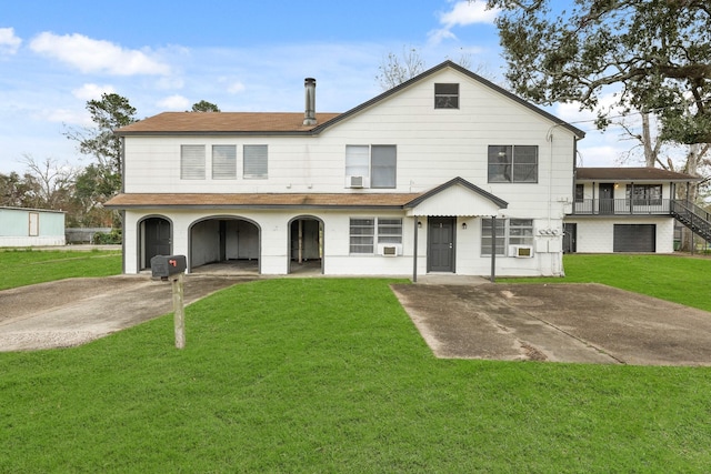 view of front of house with a garage, a front lawn, and cooling unit