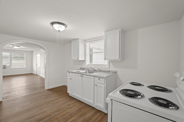 kitchen with white range with electric cooktop, sink, white cabinets, and hardwood / wood-style floors