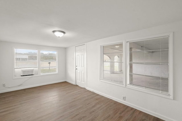 empty room with cooling unit and wood-type flooring