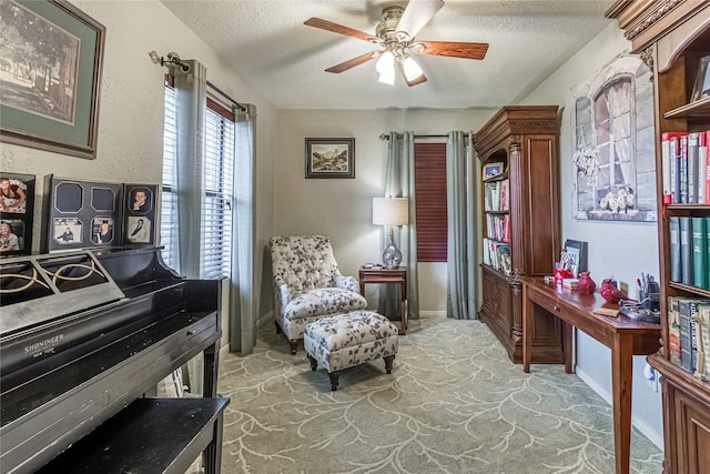 sitting room with carpet, a textured ceiling, and ceiling fan