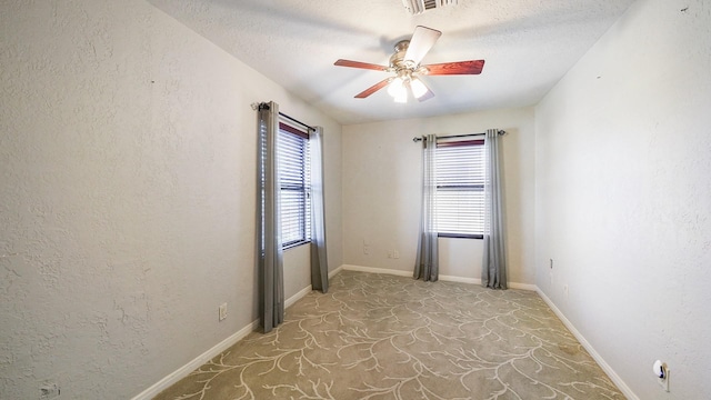 empty room featuring plenty of natural light, ceiling fan, and a textured ceiling